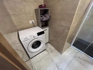 a washing machine in a bathroom next to a shower at Apartment Mandy in Rečica ob Savinji +16 photos