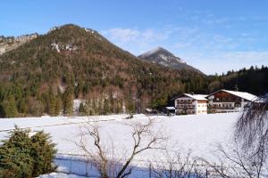 um campo coberto de neve com casas e uma montanha em Ferienhaus-Eschenlohe-Direkt-in-Bergnaehe-Wanderungen-und-Mountainbike-vom-Haus-aus-moeglich em Eschenlohe