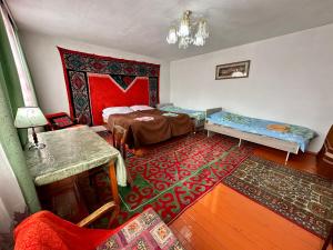 a room with two beds and a rug at Kayyr Guest House in Orgochor
