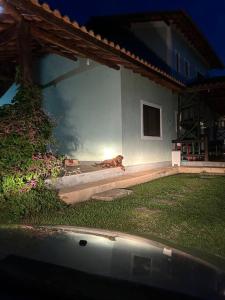 ein Hund, der auf der Seite eines Hauses liegt in der Unterkunft Sítio Paraíbuna - Fazenda Paraíbuna - Casa Campo in Paraibuna