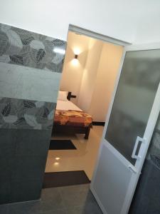 una camera con un letto e una porta che conduce a una camera da letto di Olive Cottage ad Ahangama
