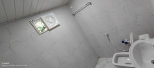 uma casa de banho com um WC, um lavatório e uma janela em Streaming Valley Independent Coffee Estate Stay em Madikeri