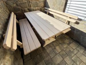 a wooden bench sitting next to a stone wall at Apartment Mandy in Rečica ob Savinji