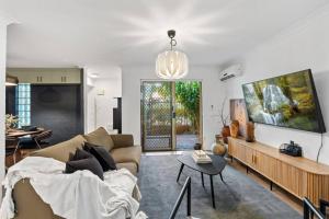 a living room with a couch and a table at 3br unit Stylish retreat SouthPerth in Perth