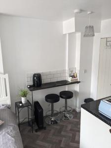 a kitchen with two bar stools and a counter at Brand New Garage Conversion in Urmston
