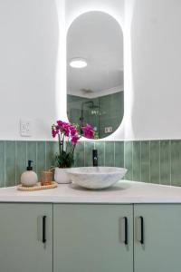 a bathroom with a white sink and a mirror at 3br unit Stylish retreat SouthPerth in Perth