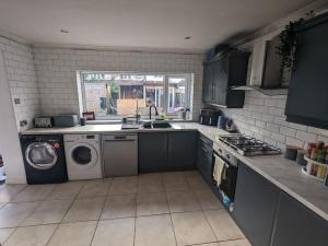 uma cozinha com um lavatório e uma máquina de lavar roupa em Brand New Garage Conversion em Urmston
