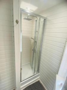 y baño con ducha y puerta de cristal. en Brand New Garage Conversion, en Urmston