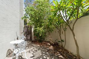 a patio with a table and chairs and trees at 3br unit Stylish retreat SouthPerth in Perth