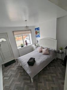 a bedroom with a bed with a bag on it at Brand New Garage Conversion in Urmston