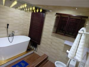 a bathroom with a white tub and a toilet at Lovely 2-Bed House in Lagos in Lagos