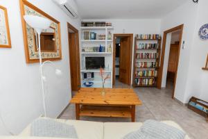 a living room with a coffee table and bookshelves at Yourhouse Villa Sa Caseta in Llubí