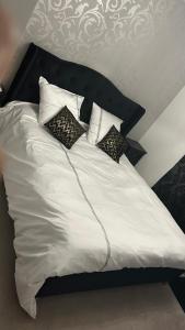 a white bed with four pillows on top of it at Chez Chris et Gildas in Gilly-sur-Isère