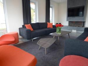 uma sala de estar com sofás e uma mesa com flores em Roggesloot em De Koog