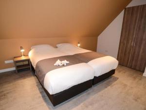 um quarto com uma cama grande com dois bichos de peluche em Roggesloot em De Koog