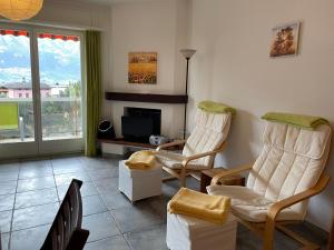 - un salon avec deux chaises et une télévision dans l'établissement Muralto-Locarno: Miramonti Apt. 8, à Muralto