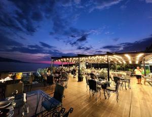 una terraza con mesas y sillas por la noche en Hotel Apollon Sarande, en Sarandë