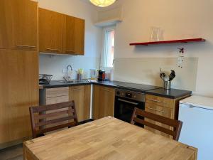 a kitchen with wooden cabinets and a table and a refrigerator at Muralto-Locarno: Miramonti Apt. 8 in Muralto +16 photos