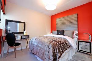 a bedroom with a bed and a desk and a mirror at Trendy apartment a short drive from Aberdeen City in Aberdeen