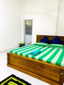 a bedroom with a large wooden bed with blue pillows at Royal Homes and Wellness Center in Kurunegala