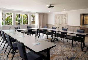 una sala de conferencias con mesas, sillas y ventanas en Hyatt House San Diego Sorrento Mesa, en Sorrento