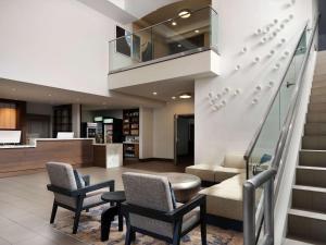 um átrio com duas cadeiras e uma escada em Hyatt House San Diego Sorrento Mesa em Sorrento