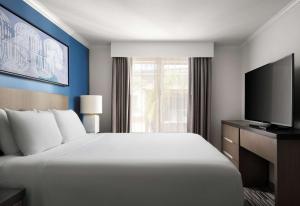 Habitación de hotel con cama grande y TV en Hyatt House San Diego Sorrento Mesa, en Sorrento