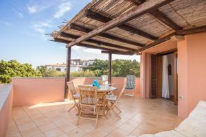 patio con mesa y sillas en el balcón en Cala Flores Gem - Sea View Lovely Apartment en Porto Cervo