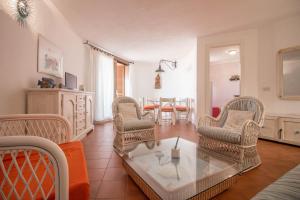 sala de estar con sillas de mimbre y mesa en Cala Flores Gem - Sea View Lovely Apartment en Porto Cervo