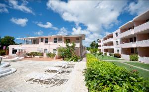 a row of white chairs in the courtyard of a building at The Monteray Hotel in Christ Church