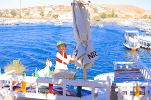 Old Nubian guest house في أسوان: طاولة مع مظلة بجانب الماء