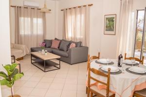 a living room with a couch and a table at Olivia House -BY APOKORNAS VILLAS in Káïna