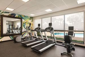 einen Fitnessraum mit Laufbändern und Crosstrainern sowie einem großen Fenster in der Unterkunft Hilton Garden Inn Palm Coast Town Center in Palm Coast