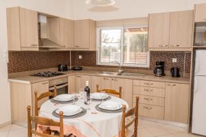 a kitchen with a table with a white table cloth at Olivia House -BY APOKORNAS VILLAS in Káïna