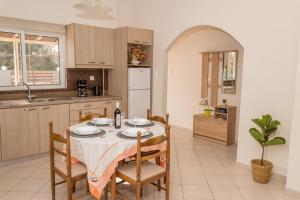 a kitchen with a table and chairs and a kitchen with a table and a table at Olivia House -BY APOKORNAS VILLAS in Káïna