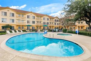 a large swimming pool in front of a building at La Quinta by Wyndham Dallas DFW Airport North in Irving