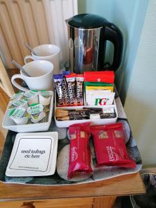 a table with food and a coffee pot on it at Pebbles House in Seaton