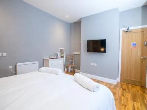 een slaapkamer met een groot wit bed en een flatscreen-tv bij Pass the Keys Stonebow room at Tavmar Apartments in Lincoln