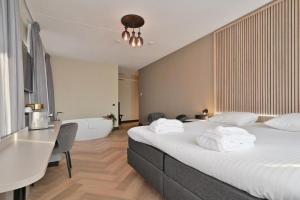 a bedroom with a large bed with white towels on it at Hotel Alkmaar - Bar & Restaurant in Alkmaar
