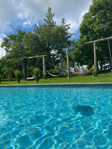 a swimming pool with two swings and blue water at Hotel - Restaurant Bastenhaus in Dannenfels