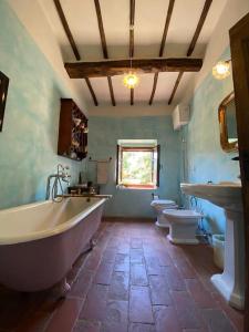 baño con 2 aseos, bañera y 2 lavabos en Panoramic view from stone Apartment- Pool and A/C, en Montevarchi