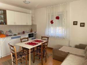 Una cocina y una sala de estar con mesa y sillas. en Apartman Kovacevic, en Zlatibor