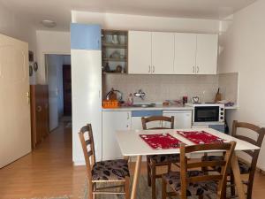 Una cocina y un comedor con mesa y sillas. en Apartman Kovacevic, en Zlatibor