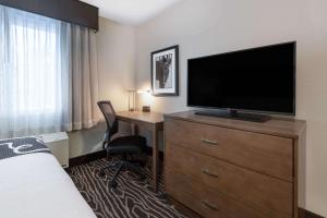 a hotel room with a desk and a television on a dresser at La Quinta by Wyndham Fairbanks Airport in Fairbanks