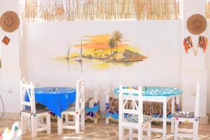 a dining room with a table and chairs and a painting at Old Nubian guest house in Aswan