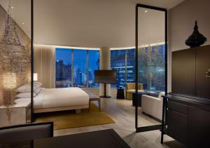 a bedroom with a bed and a view of a city at Park Hyatt Bangkok in Bangkok