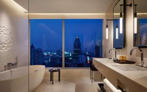baño con bañera y ventana con vistas a la ciudad en Park Hyatt Bangkok, en Bangkok
