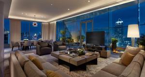 ein Wohnzimmer mit einem Sofa, einem TV und einem Tisch in der Unterkunft Park Hyatt Bangkok in Bangkok