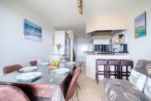 a dining room and kitchen with a table and chairs at Soleil du Crouesty - garage et piscine partagée in Arzon