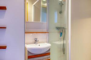 a bathroom with a sink and a shower at Soleil du Crouesty - garage et piscine partagée in Arzon +8 photos